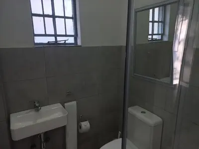 a bathroom with a toilet and a sink and a mirror at Triple9 Hatfield Guesthouse in Pretoria