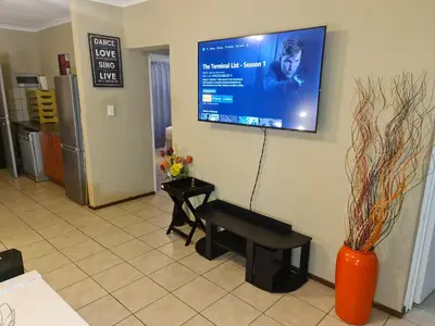 a waiting room with a bench and a screen on the wall at Midrand Ninth on Lever Shalom in Midrand