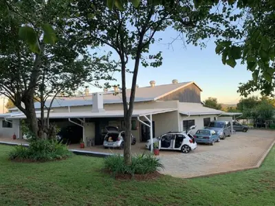 a building with cars parked in a parking lot at Stay Harties Accommodation in Hartbeespoort