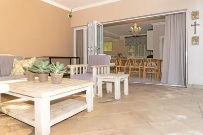 a living room with a table and chairs at Bela Rini Guesthouse in Bela-Bela