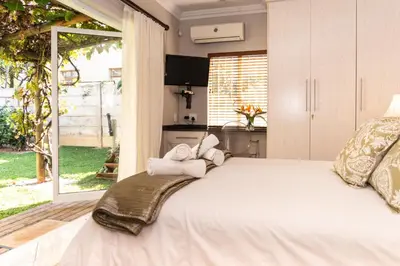 a bedroom with a large bed with towels on it at Bela Rini Guesthouse in Bela-Bela
