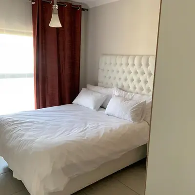 a bedroom with a white bed with a large window at THE BLYDE CRISTAL LAGOON in Pretoria