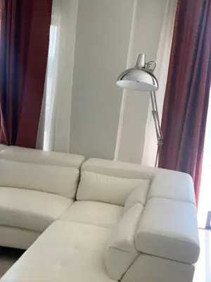 a living room with a white couch and a lamp at THE BLYDE CRISTAL LAGOON in Pretoria