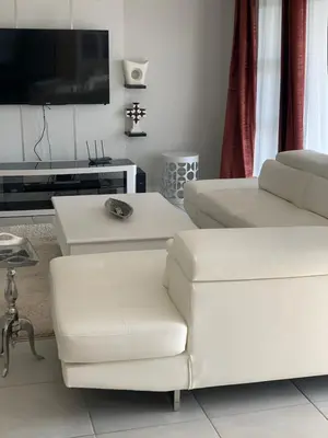 a living room with white furniture and a flat screen tv at THE BLYDE CRISTAL LAGOON in Pretoria