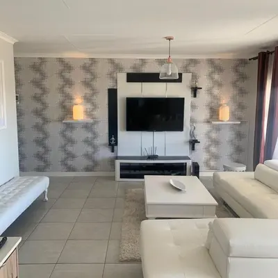 a living room with a couch and a tv at THE BLYDE CRISTAL LAGOON in Pretoria