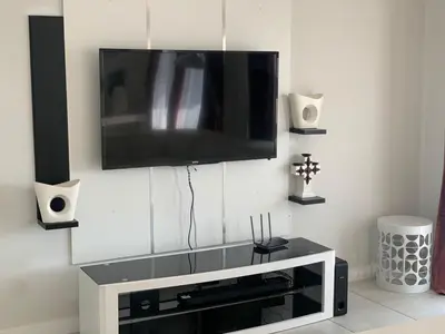 a living room with a flat screen tv on a wall at THE BLYDE CRISTAL LAGOON in Pretoria