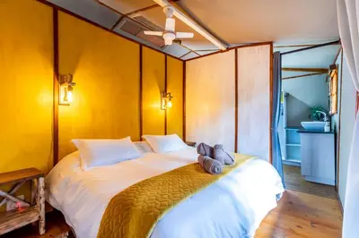 a bedroom with a bed with towels on it at Jabula Bush Camp in Klipdrift