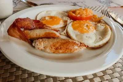 a plate of breakfast food with eggs sausage and bacon at Franks Bush Camp in Hoedspruit