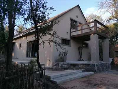 a house with a staircase in front of it at The Aloes Bush Lodge in Marloth Park