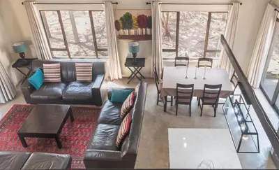 a living room with a couch and a table at The Aloes Bush Lodge in Marloth Park