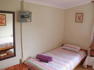 a small bedroom with a bed and a mirror at Goederus Guest Farm in Sterkspruit