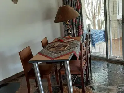 a table with chairs and a lamp on top of it at Goederus Guest Farm in Sterkspruit