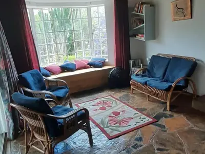 a living room with two chairs and a window at Goederus Guest Farm in Sterkspruit