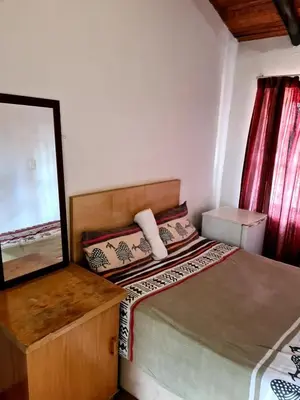 a small bedroom with a bed and a mirror at Baraka House in Midrand