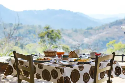 a table with plates of food on top of a mountain at Tomjachu Bush Retreat in Nelspruit