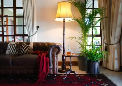 a living room with a couch and a lamp at Tomjachu Bush Retreat in Nelspruit