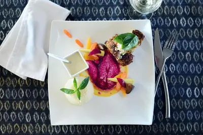 a white plate with food on a table at Tomjachu Bush Retreat in Nelspruit