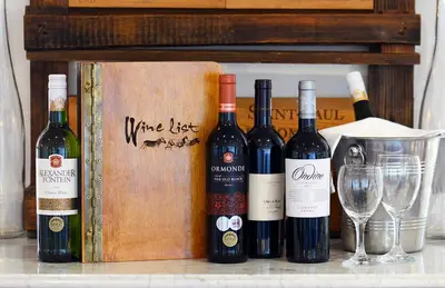 a group of wine bottles and glasses on a counter at Tomjachu Bush Retreat in Nelspruit