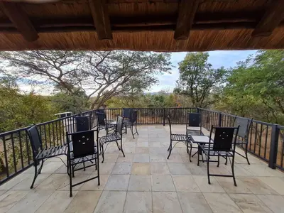 a group of chairs and tables on a patio at Pumba's Place Zebula 6 Bedroom House in Mabula