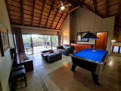 a living room with a pool table in it at Pumba's Place Zebula 6 Bedroom House in Mabula