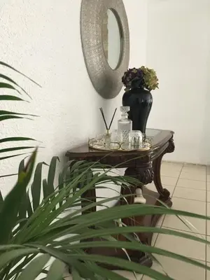 a table with a mirror and a vase and a plant at Maso palace in Polokwane