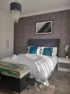 a bedroom with a large bed and a chandelier at Maso palace in Polokwane
