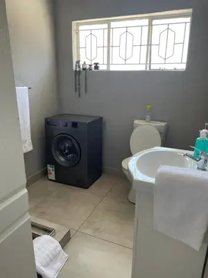 a bathroom with a washing machine and a sink at Maso palace in Polokwane