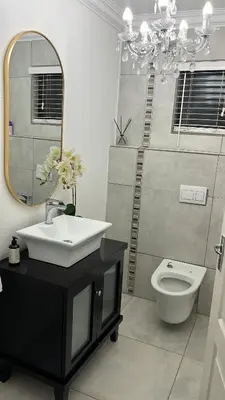 a bathroom with a sink and a mirror and a toilet at Maso palace in Polokwane