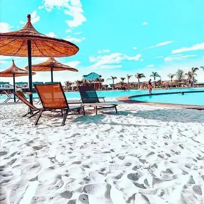 two chairs and umbrellas on a beach with a pool at The Blyde Unit 1321 in Pretoria