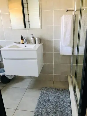 a bathroom with a white sink and a shower at The Blyde Unit 1321 in Pretoria