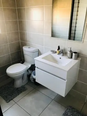 a bathroom with a white toilet and a sink at The Blyde Unit 1321 in Pretoria