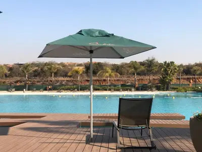 a chair and an umbrella in front of a pool at The Blyde Unit 1321 in Pretoria