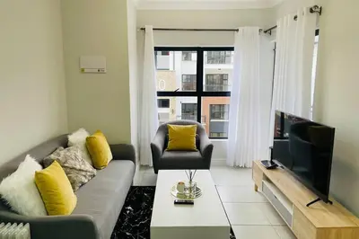 a living room with a couch and a television at The Blyde Unit 1321 in Pretoria
