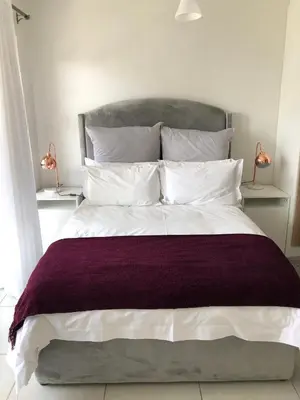 a bedroom with a large bed with white pillows at The Blyde Unit 1321 in Pretoria