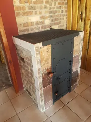 a brick fireplace with a black counter top at Rainbow Lodge in Belfast