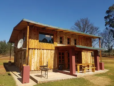a small wooden building with a picnic table in front at Rainbow Lodge in Belfast