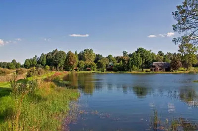 a view of a lake with a house in the background at Rainbow Lodge in Belfast