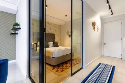 a bedroom with a bed and a glass walled shower at Alimama Spaces: The Chelsea's Ellipse in Midrand