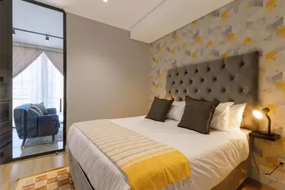 a bedroom with a large bed with a large window at Alimama Spaces: The Chelsea's Ellipse in Midrand