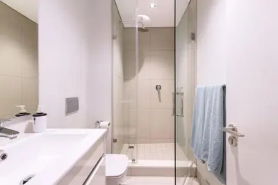 a bathroom with a shower and a sink and a toilet at Alimama Spaces: The Chelsea's Ellipse in Midrand