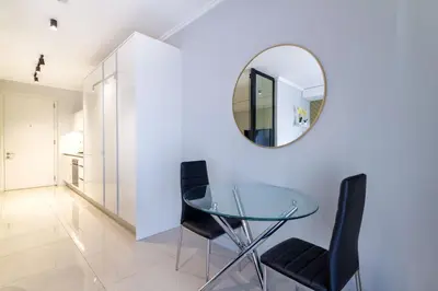 a glass table with black chairs and a mirror at Alimama Spaces: The Fountain Hill Ellipse in Midrand