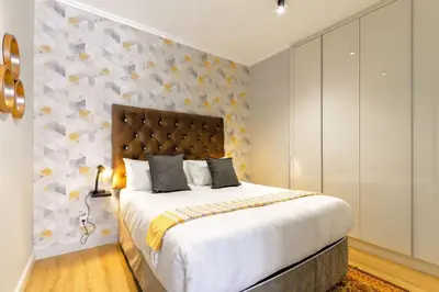 a bedroom with a large bed and a wall at Alimama Spaces: The Manson's Ellipse in Midrand