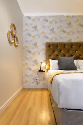 a bedroom with a large bed with a stone wall at Alimama Spaces: The Manson's Ellipse in Midrand
