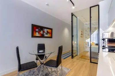 a dining room with a glass table and chairs at Alimama Spaces: The Manson's Ellipse in Midrand