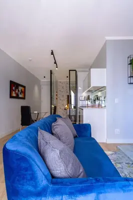 a blue couch with pillows on it in a living room at Alimama Spaces: The Manson's Ellipse in Midrand
