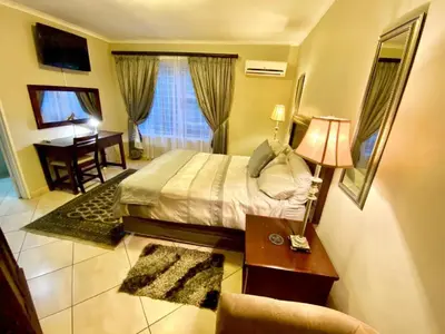 a hotel room with a bed and a desk and a desk at Absolut Guest Boutique in Centurion