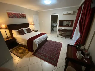 a bedroom with a bed and a living room with a desk at Absolut Guest Boutique in Centurion