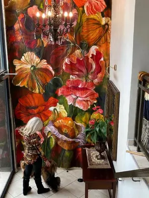 a person standing next to a painting of flowers at Absolut Guest Boutique in Centurion