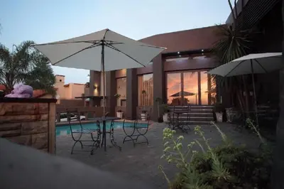 a patio with a table and chairs and an umbrella at Absolut Guest Boutique in Centurion
