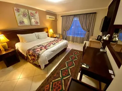 a bedroom with a bed and a desk and a window at Absolut Guest Boutique in Centurion